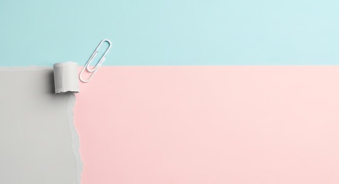 Minimalist composition of a white correction fluid bottle with a paper clip on a pastel background.
