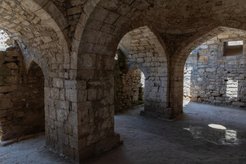 Fototapeta premium Interior view of ancient stone vaults and arches in Naryn-Kala fortress, Derbent, Republic of Dagestan, Russia, with sunlight and shadows on old masonry