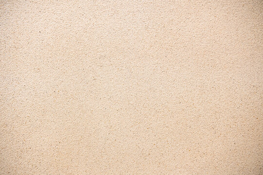 Beige sand wall texture background. Abstract grainy plaster surface for architectural design and construction backdrop. Natural light brown cement or stone finish with fine detailed material.