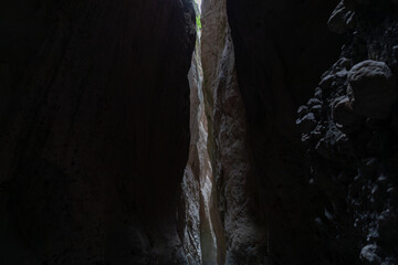 View inside the narrow Karadakh Gorge with towering rock walls and a thin strip of daylight above, a famous natural landmark in Dagestan, Russia, Caucasus region © TravelFlow