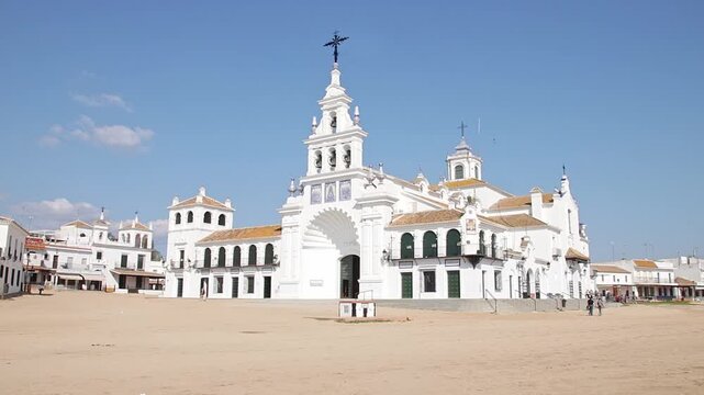 Wide shot of the famous Sanctuary of Our Lady of El Rocio in Almonte. Iconic Andalusian architecture under a clear blue sky, ideal for travel and culture content.
