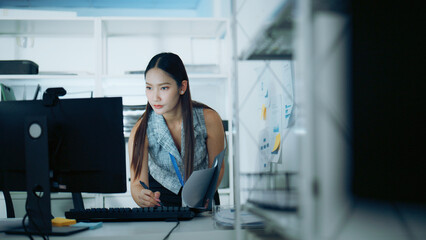 Businesswoman with folder works at computer in modern office, showing focus, planning, technology,...