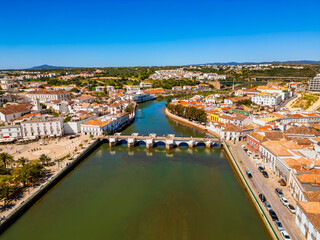 Obraz premium High angle Drone Point of View on the Old Town of Tavira, Algarve, Portugal with the Gilão River and the famous Ponte Romana Medieval Roman Bridge