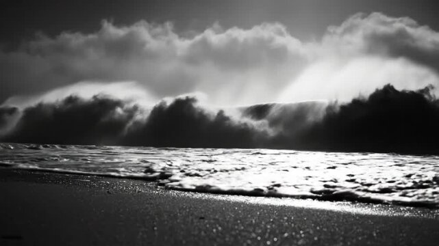 Dramatic ocean wave crashing on beach with sunlight in black and white nature landscape