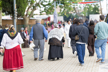 Obraz premium People walk together in a lively street during a cultural festival in the afternoon