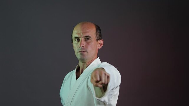 A young athlete practices punching against a multi-colored background with flashing lights