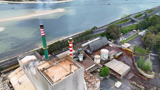 Industrial pulp and paper mill aerial view emitting smoke