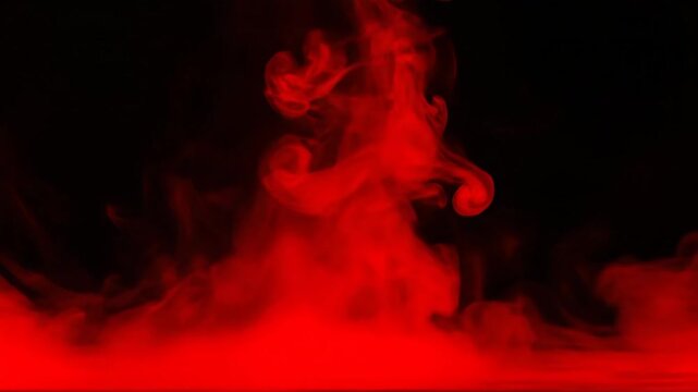 Abstract Red Smoke on Black Background - This video showcases abstract red smoke against a stark black background. The red mist gives the appearance of a fog rolling across the ground.