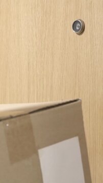 Delivery direct to your door.Photo of a courier delivering a box to a customer and knocking on the door inside a building