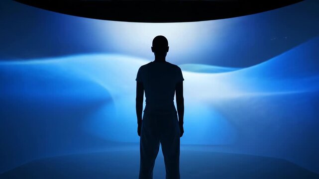 Silhouette Against a Blue Abstract Background - The video features a solitary figure silhouetted against a vibrant blue abstract background.