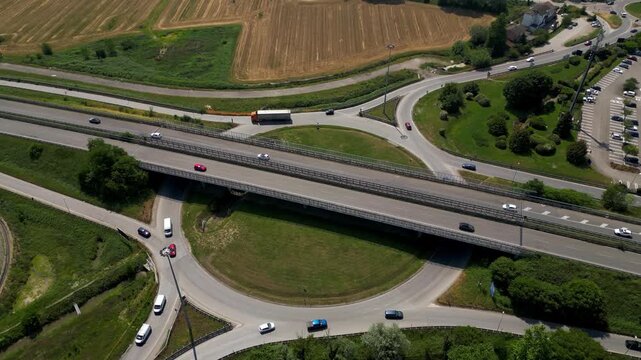 Highway Intersection: An elevated highway gracefully intersects with a network of circular roadways, showcasing the seamless flow of traffic within a vibrant, organized infrastructure.