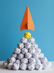 Obraz premium Orange paper rocket launches from pile of crumpled paper balls with one yellow ball on top. Metaphor for new ideas, creativity, and startup.