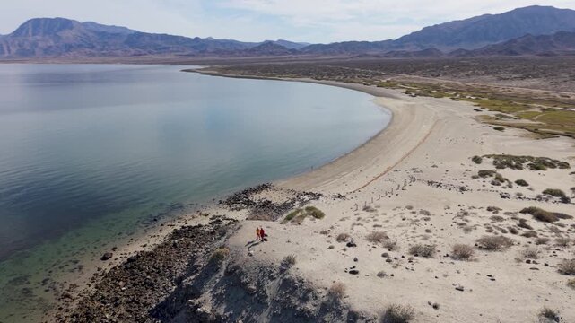 Couple celebrates outdoors on a cliff overlooking La Gringa at Bahia De Los Angeles in Baja California enjoying nature and adventure