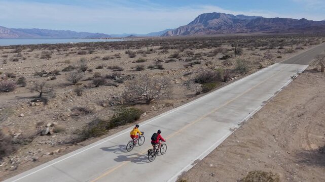 Aerial view of mature man and woman biking along the road by the Sea of Cortez near La Gringa in Baja California Mexico.