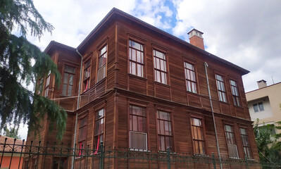 Fototapeta premium Two-story Ottoman timber house with ornate wooden facade and large windows in historic Edirne neighborhood, Turkey. Heritage residential building.