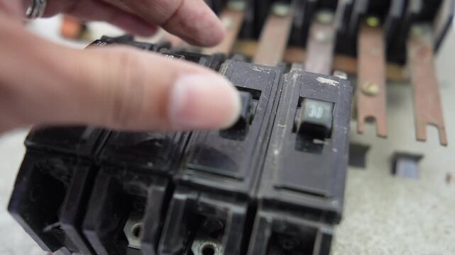Hand handling old circuit breakers and electrical busbars