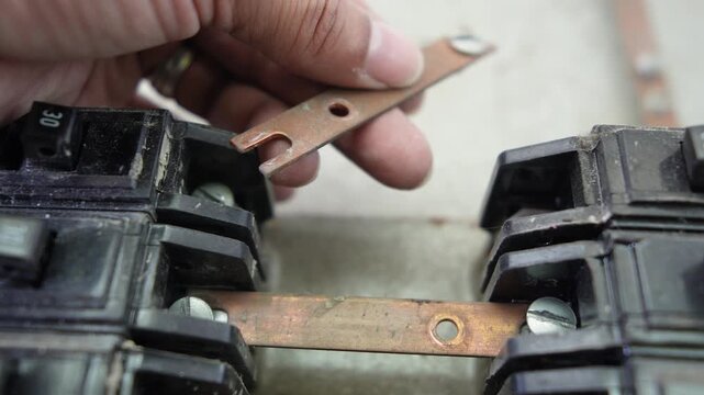 Hand handling old circuit breakers and electrical busbars