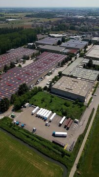 Industrial Aerial View: An expansive aerial perspective reveals a modern industrial complex, showcasing rows of warehouses and logistics infrastructure, highlighting the scale of commerce and trade.