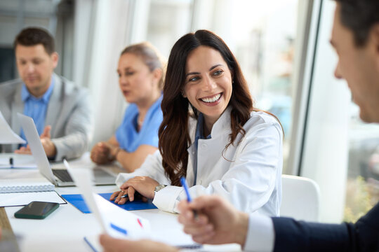 Smiling female doctor cooperating with businessman  during a meeting  in a hospital.