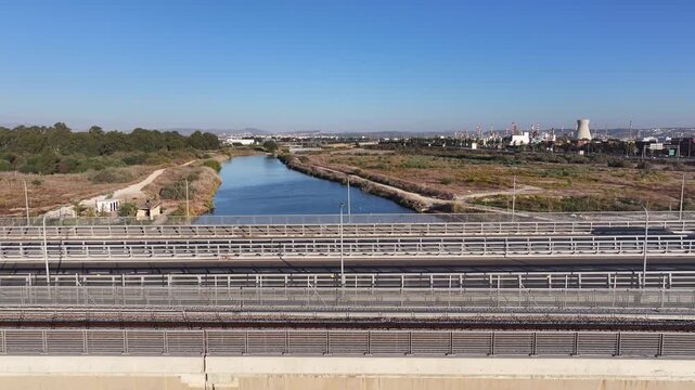 Aerial drone view of traffic on the bridge over the Kishon River with Haifa Bay industrial zone and refineries in the background