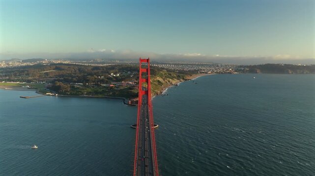 Centered drone view of Golden Gate Bridge with traffic and blue bay water