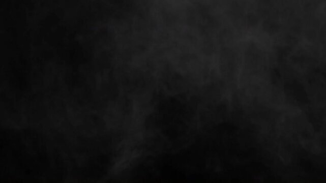 Mysterious grey smoke wisps drifting slowly across a dark black background creating an atmospheric effect.