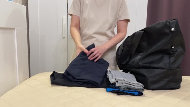 Women organizing clothes, Person meticulously categorizing clothing items before packing them away, Woman carefully sorting and comparing shirts and trousers before placing them into bag