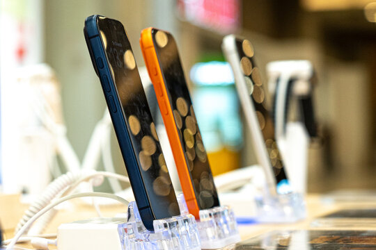 Showcasing Modern Smartphones with Unique Designs Displayed Elegantly on Stands in a Retail Setting with Soft Background Lighting