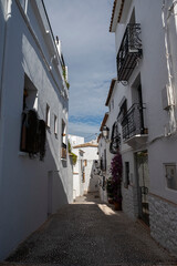 Obraz premium Narrow cobblestone alley with white houses and wrought iron balconies in the old town of Altea, Alicante, Spain.