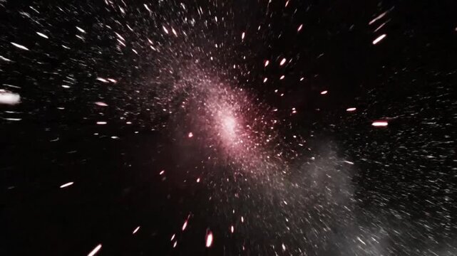 Exploding firework display with bursts of brilliant light and smoke in dark night sky celebrating a special occasion