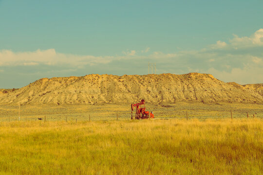 Lone pumpjack in a rural grassland landscape
