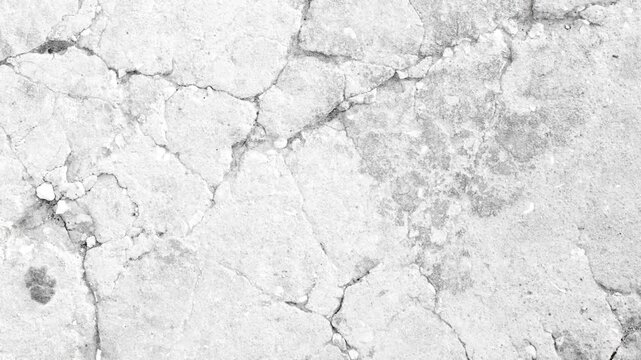 Close-up of cracked white plaster wall with rough texture and subtle shadows
