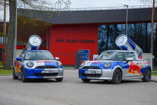 Valmiera,Latvia-May 10,2026-Red Bull branded Mini Cooper cars with giant tin cans parked outside Jānis Daliņ&scaron; Stadium.