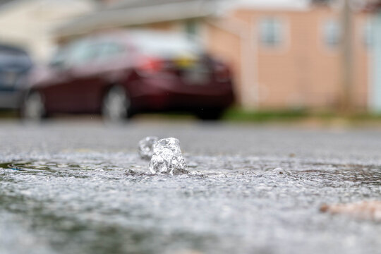 Photo of a Water Main Break on a Road coming up through a service hole