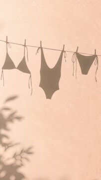 Minimalist summer vacation concept with bikini and swimsuit shadows on a textured pastel peach wall