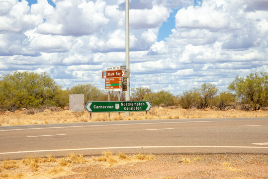 Road Signs Pointing to Carnarvon, Northampton, Geraldton and Shark Bay in the Australian Outback Under Cloudy Sky, Western Australia, 24 February 2023