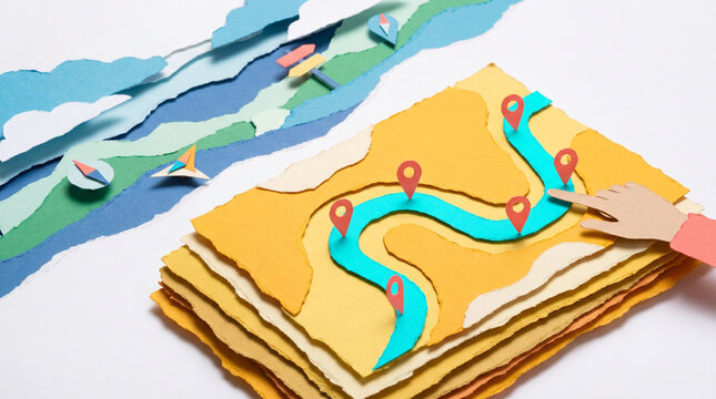 Colorful paper map with markers showing a route on a table  