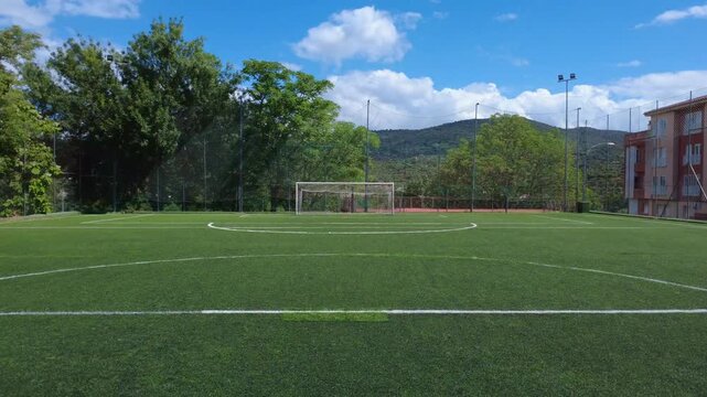 Aerial shot of a football field, taking off and flying forward