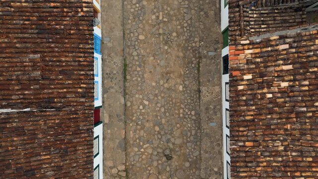 Overhead aerial view of colonial cobblestone street with tourists walking and street intersection in UNESCO World Heritage Site of Paraty, Brazil. Push in camera movement