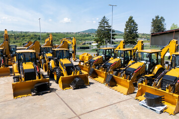 New hydraulic excavators and tractors parked at a construction machinery dealership © scharfsinn86