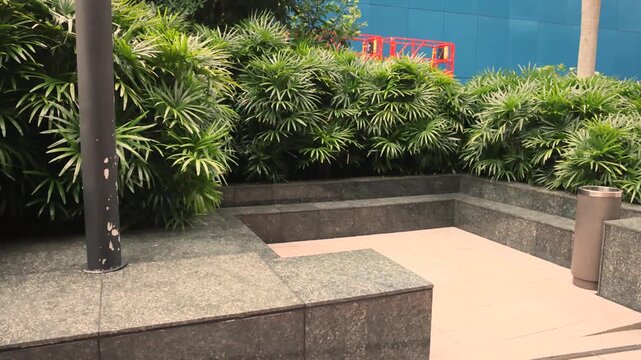 Caged legal outdoor smoking point surrounded by office buildings and pedestrian walkway. Visible safety rules and regulatory signs. Representation of Asian urban governance and smoke-free initiatives.