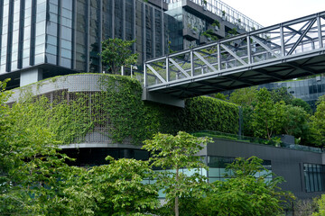 Fototapeta premium A stunning building covered in greenery stands out against the city skyline, showcasing an innovative design that celebrates urban nature and sustainability.