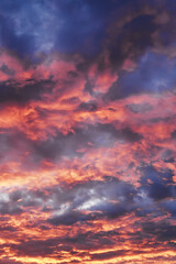 Sunset sky showing colorful clouds illuminated with red and orange light © colnihko