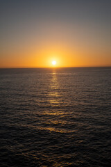 Obraz premium breathtaking ocean sunset casting warm hues over tranquil sea horizon at evening twilight