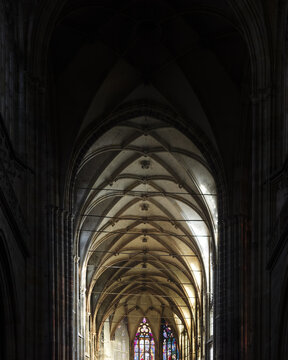 View of the intricate Gothic ribbed vaulting and stone arches inside St. Vitus Cathedral with stained glass windows in Prague, Prague, Czechia.