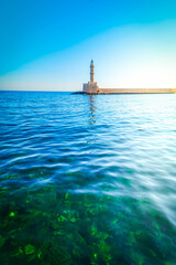 Fototapeta premium bay of Chania with sea and lighthouse at sunny summer sunset, Crete, Greece, web banner format