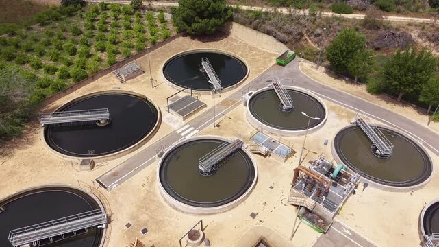 Aerial view of modern urban wastewater treatment plant showing circular clarifiers, aeration basins with activated sludge, and biological nitrogen and phosphorus removal systems