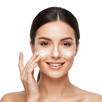 A woman applying facial cream while looking in the mirror with a clean and radiant complexion
