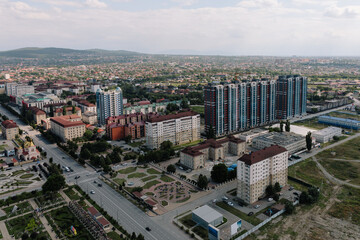 Fototapeta premium Elevated rooftop panorama of Grozny City showing modern high-rise residential towers, streets and parks under cloudy sky, Grozny, Chechen Republic, Russia