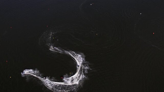 Aerial View of Jet Skis Making Sharp Turns and Leaving S-Shape Foam Trails